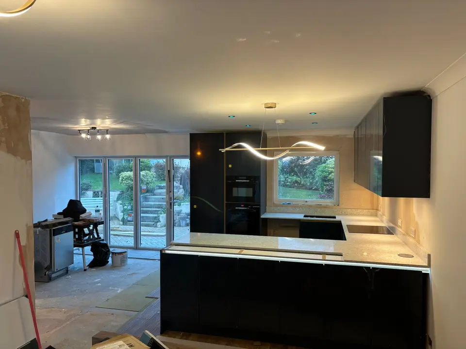 Downlights, LED plinth strip and a statement wave pendant over a new kitchen