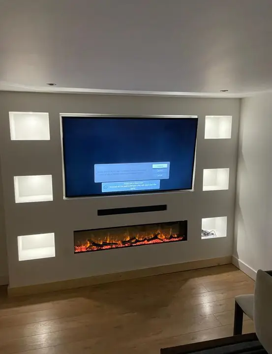 Media wall with lit alcoves and an inset electric fire
