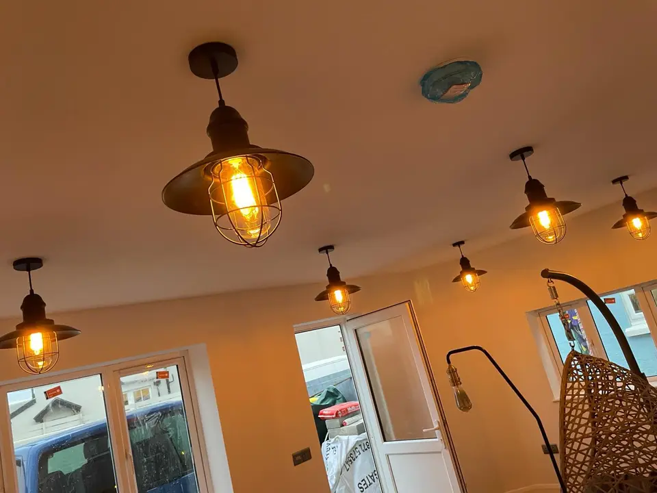 Caged pendant lights installed across an open-plan room